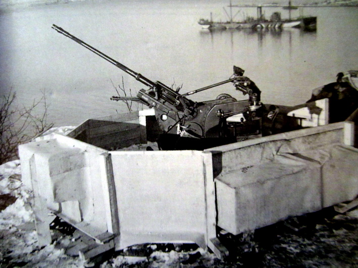 Her er et bilde tatt i krigens dager oppe på selve Kronå, og viser den provisoriske 2cm Flak-stillingen sammensatt av treverk. Dette var nok før det ble fylt på m. stein og jord rundt den. En ganske &quot;standard&quot; 2cm Flak-stilling m. ammonisjer etc. En &quot;form&quot; egentlig til støyping kanskje?