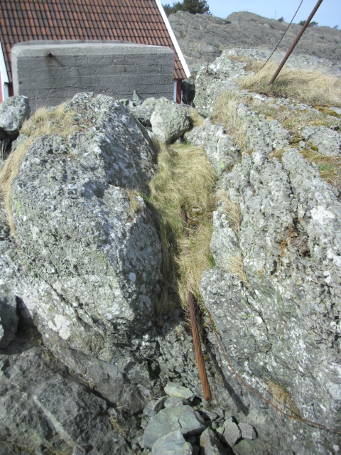 Kabelgate forran bunkeren sett fra sjøsiden. En 4-5cm tykk kabel ligger i kabelgaten. Dere får vurdere om den er fra krigen da eg ikke har peiling på slikt.